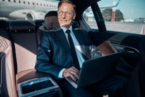 Jolly,Mature,Elegant,Male,Is,Using,Notebook,While,Driver,Is